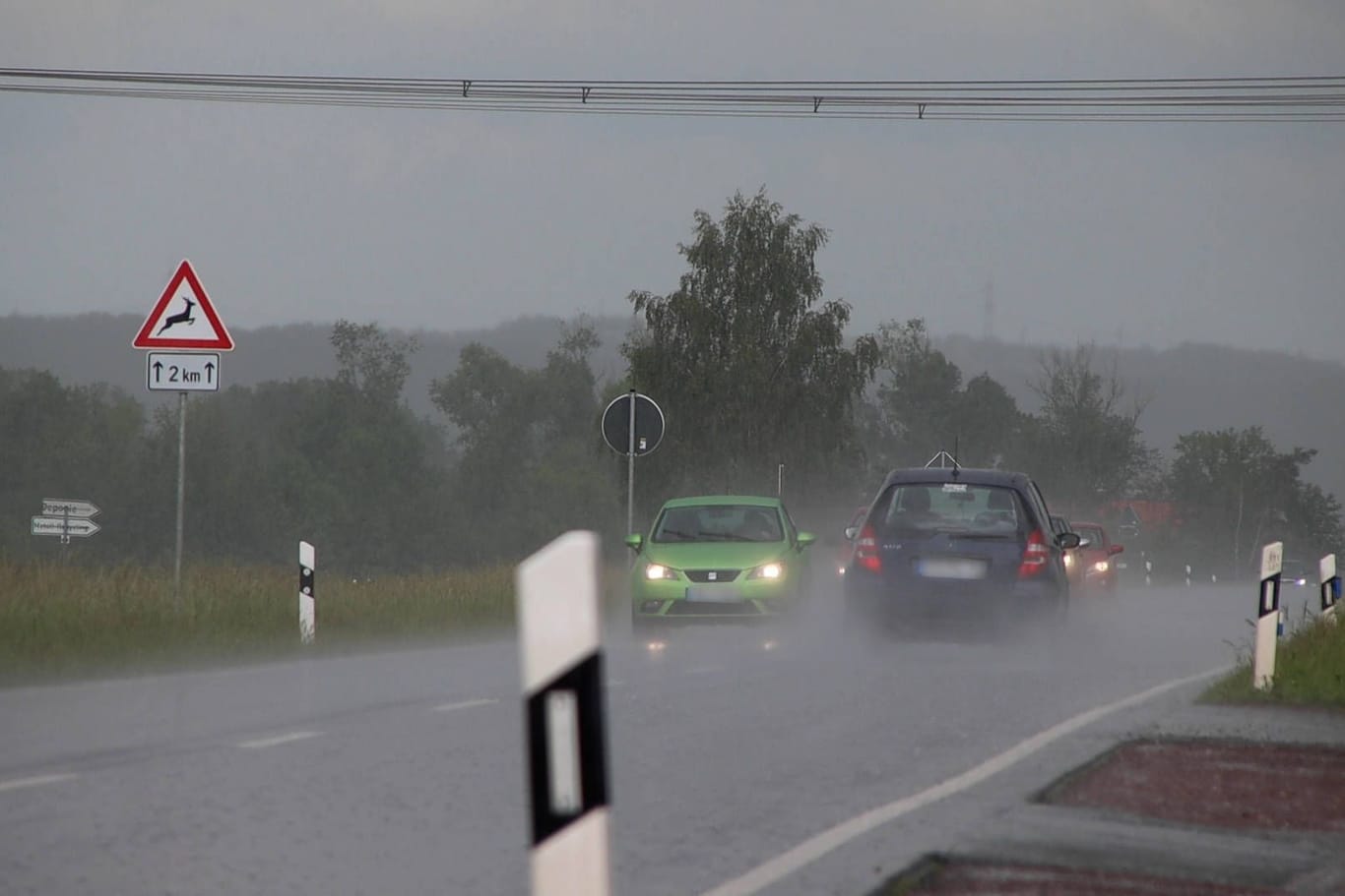 Kräftiger Schauer und Gewitter auf einer Landstraße (Symbolbild): Die Unwetter sollen bis mindestens Donnerstag anhalten.