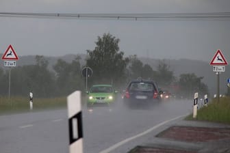Kräftiger Schauer und Gewitter auf einer Landstraße (Symbolbild): Die Unwetter sollen bis mindestens Donnerstag anhalten.