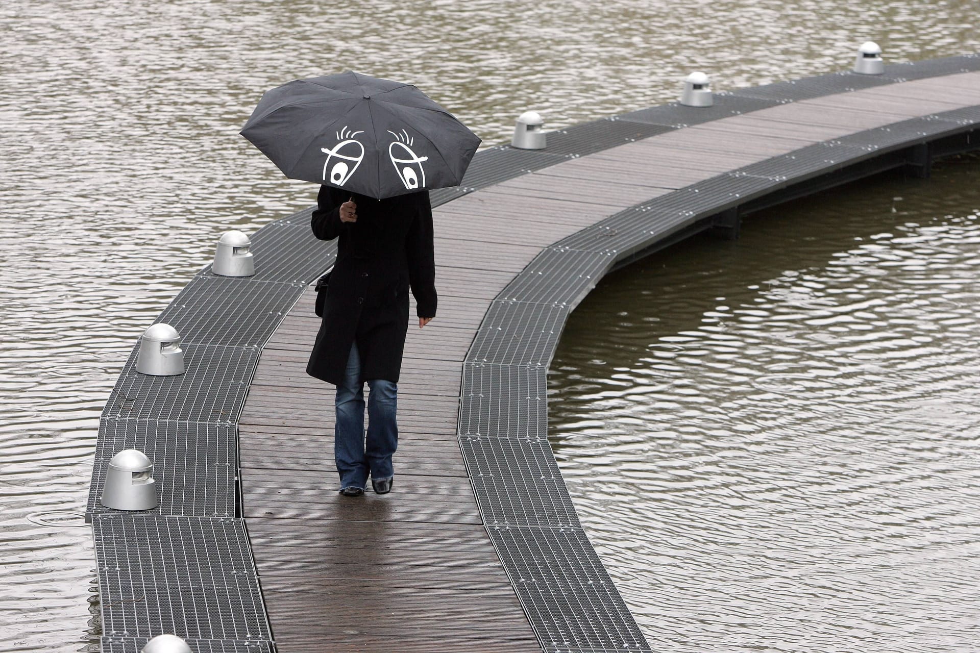 Eine Fußgängerin schützt sich mit einem Regenschirm (Symbolfoto): In Bremen soll es in der Nacht zu Dienstag stark regnen.