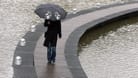 Eine Fußgängerin schützt sich mit einem Regenschirm (Symbolfoto): In Bremen soll es in der Nacht zu Dienstag stark regnen.
