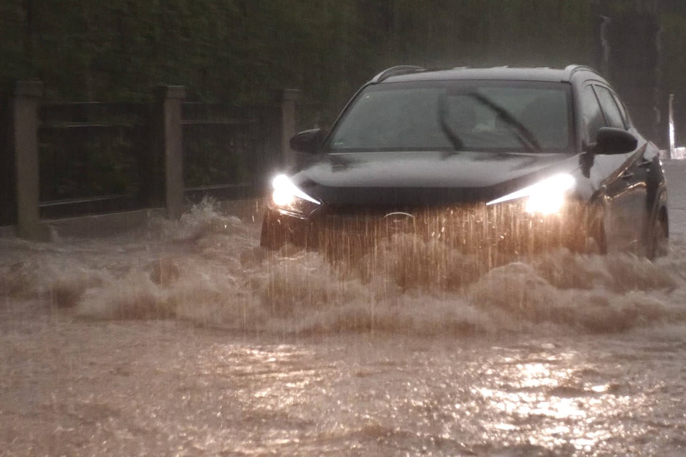 Autos fahren bei starkem Regen durch tiefe Pfützen (Symbolbild): Am Wochenende drohen extreme Niederschlagsmengen.
