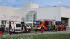 Murnau: Rettungskräfte und Einsatzkräfte der Feuerwehr stehen vor der abgeriegelten Notaufnahme des Unfallklinikums Murnau.