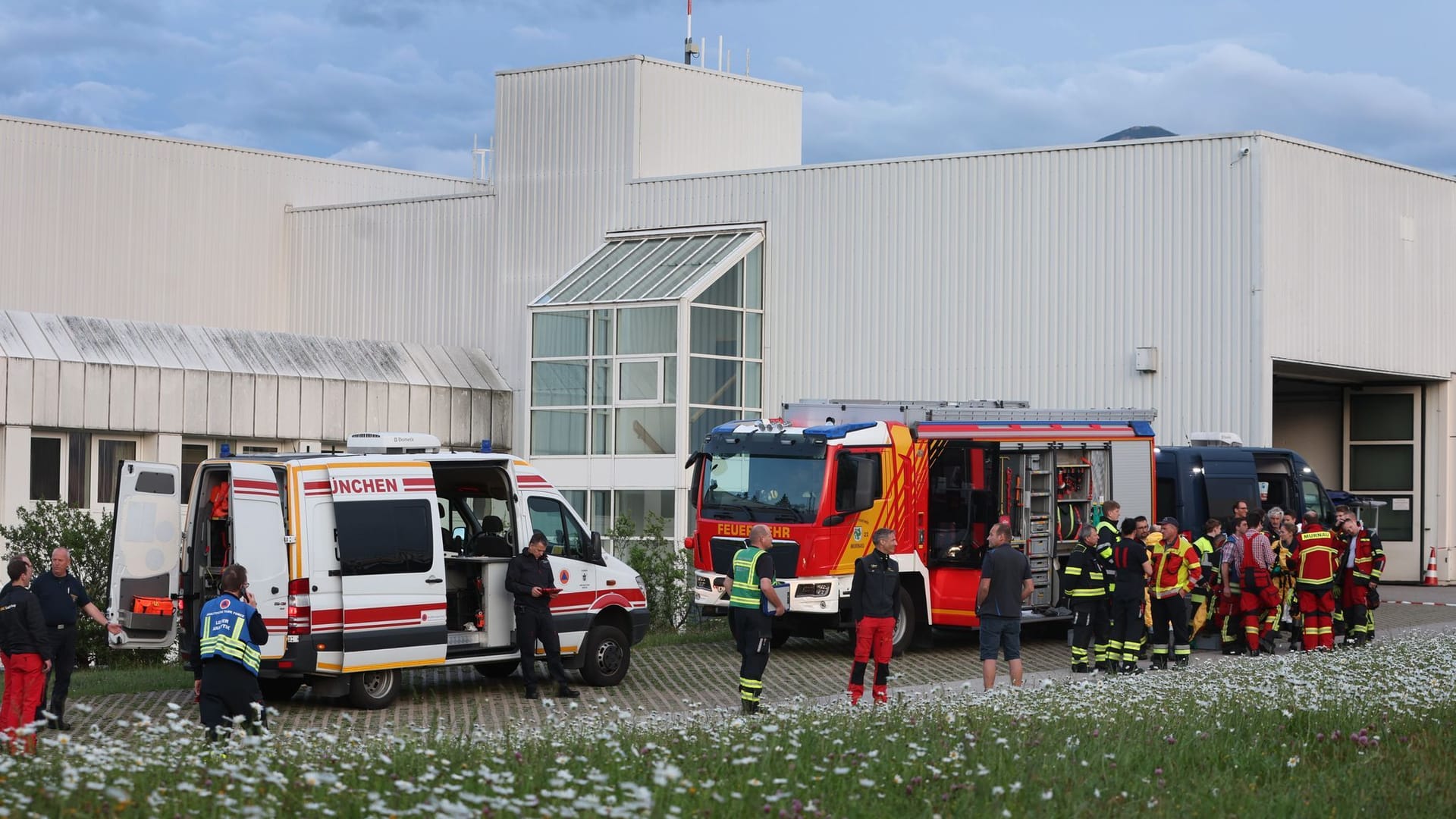 Murnau: Rettungskräfte und Einsatzkräfte der Feuerwehr stehen vor der abgeriegelten Notaufnahme des Unfallklinikums Murnau.