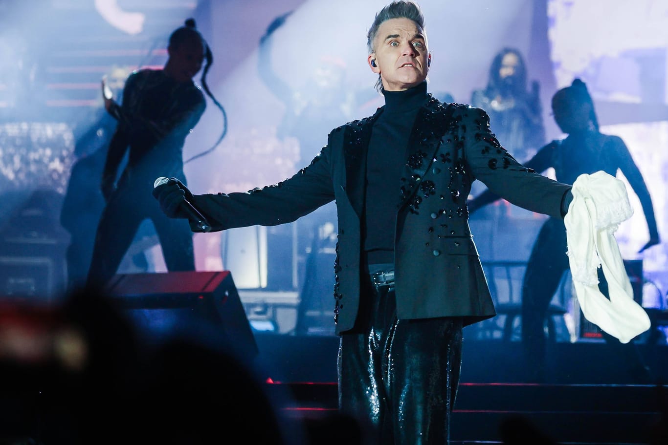 Robbie Williams während eines Konzerts (Archivbild): Der 50-Jährige kommt im Sommer überraschend nach Hamburg.