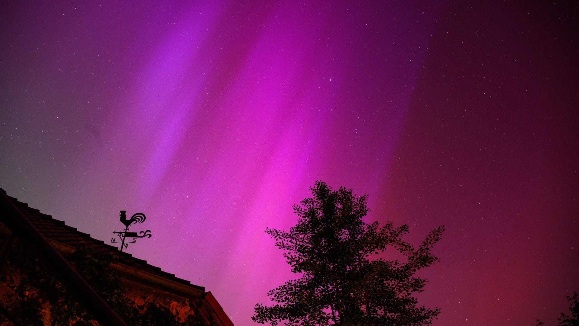 Polarlichter sind hinter einem Wetterhahn am Kloster Wülfinghausen bei Eldagsen südlich von Hannover zu sehen.