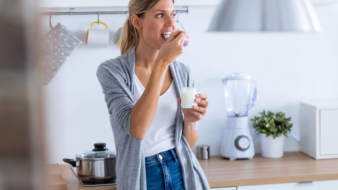 Frau isst einen Joghurt