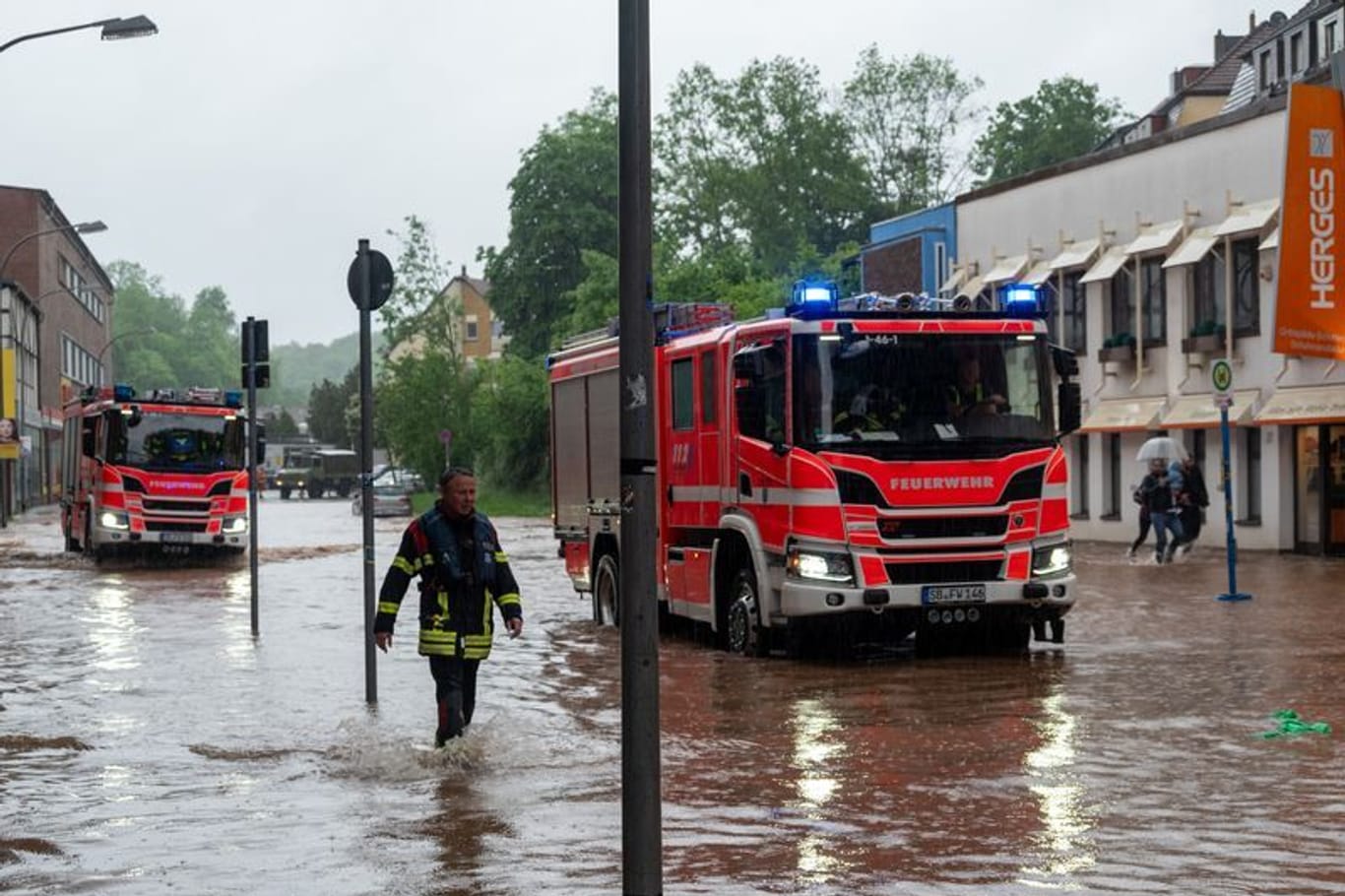 Feuerwehrleute bewegen sich durch das Hochwasser in Saarbrücken.