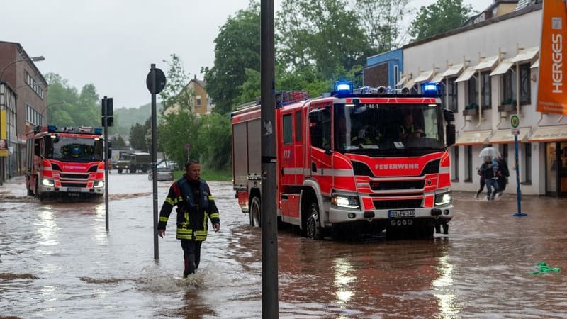 Feuerwehrleute bewegen sich durch das Hochwasser in Saarbrücken.