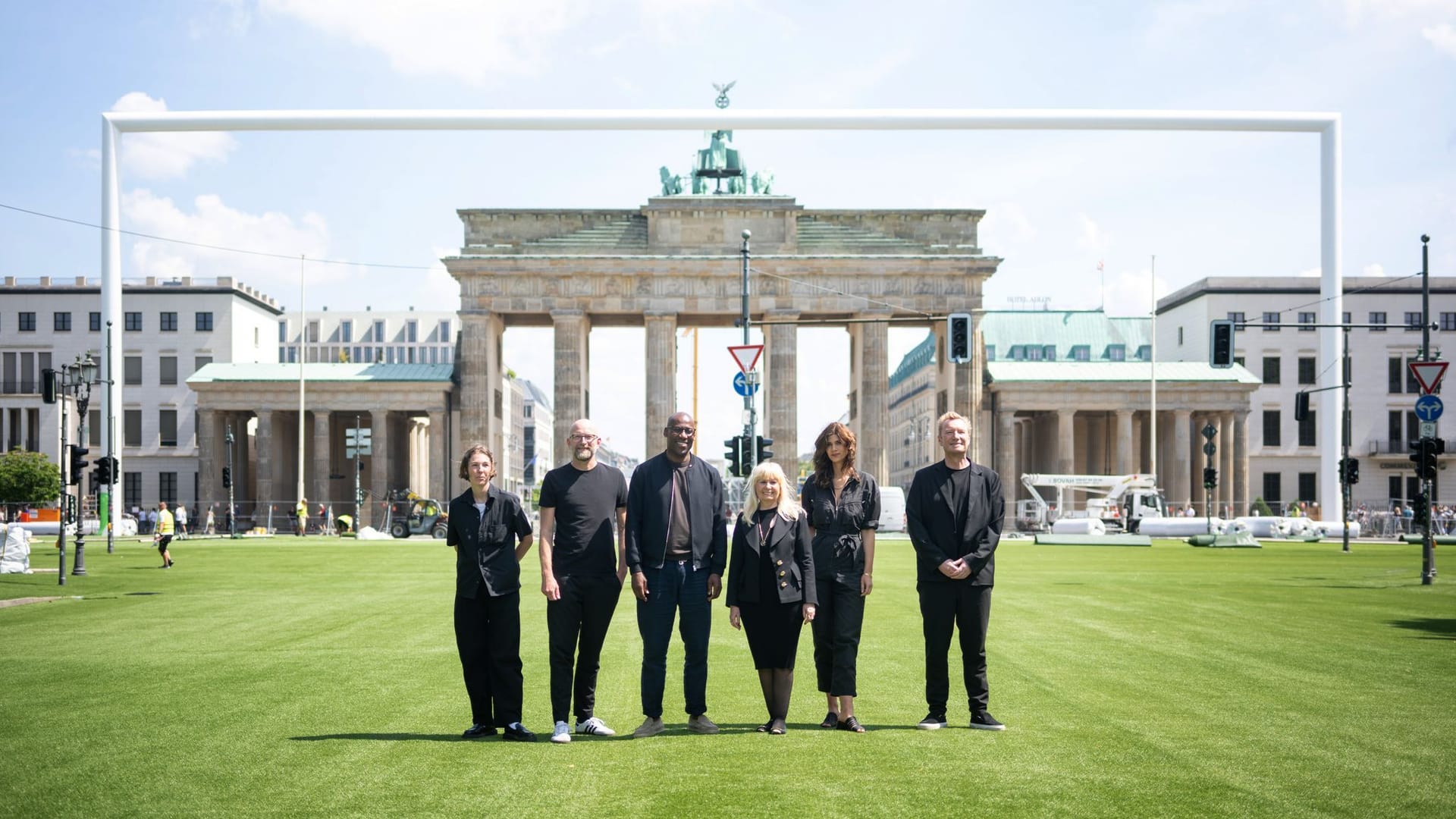 Berlin: Joe Chialo (CDU), Berliner Kultursenator, und Iris Spranger (SPD), Berliner Senatorin für Inneres und Sport, stehen mit weiteren Verantwortlichen des Berliner Fußballsommers vor dem Brandenburger Tor.