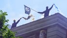 Demonstrierende halten Bengalos und eine Anarchisten-Fahne: Die Rote Flora spielt eine große Rolle bei 1. Mai-Demos.