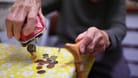Rentnerin schüttet Münzen auf den Küchentisch: Das Rentenpaket der Ampel-Koalition soll die gesetzliche Rente langfristig sichern.