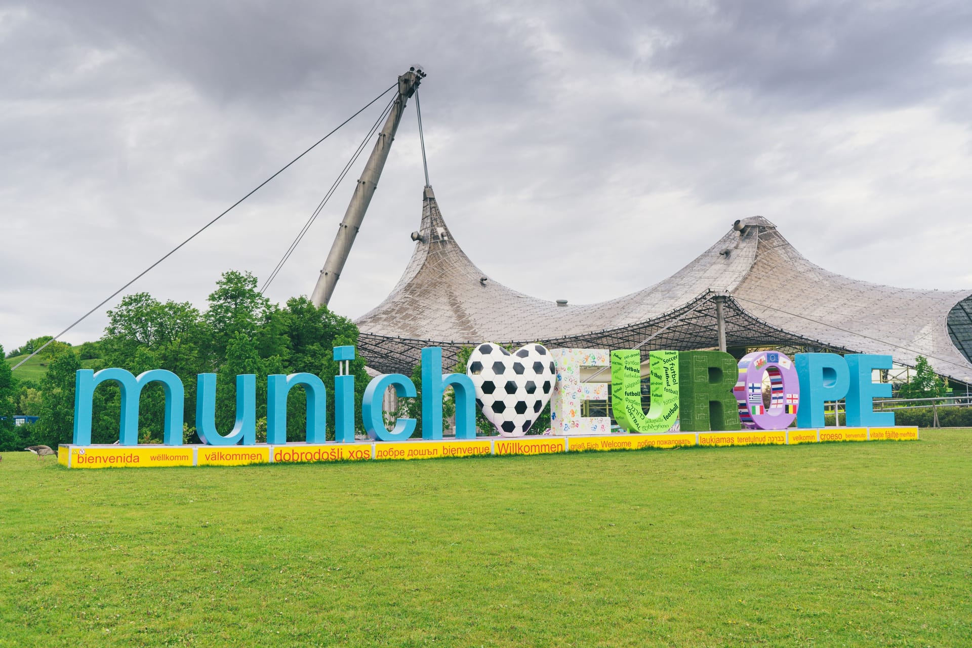 Ein Schriftzug weist auf die Fußball-EM in München hin: Im Olympiapark wird es 31 Tage lang eine Fan Zone geben.