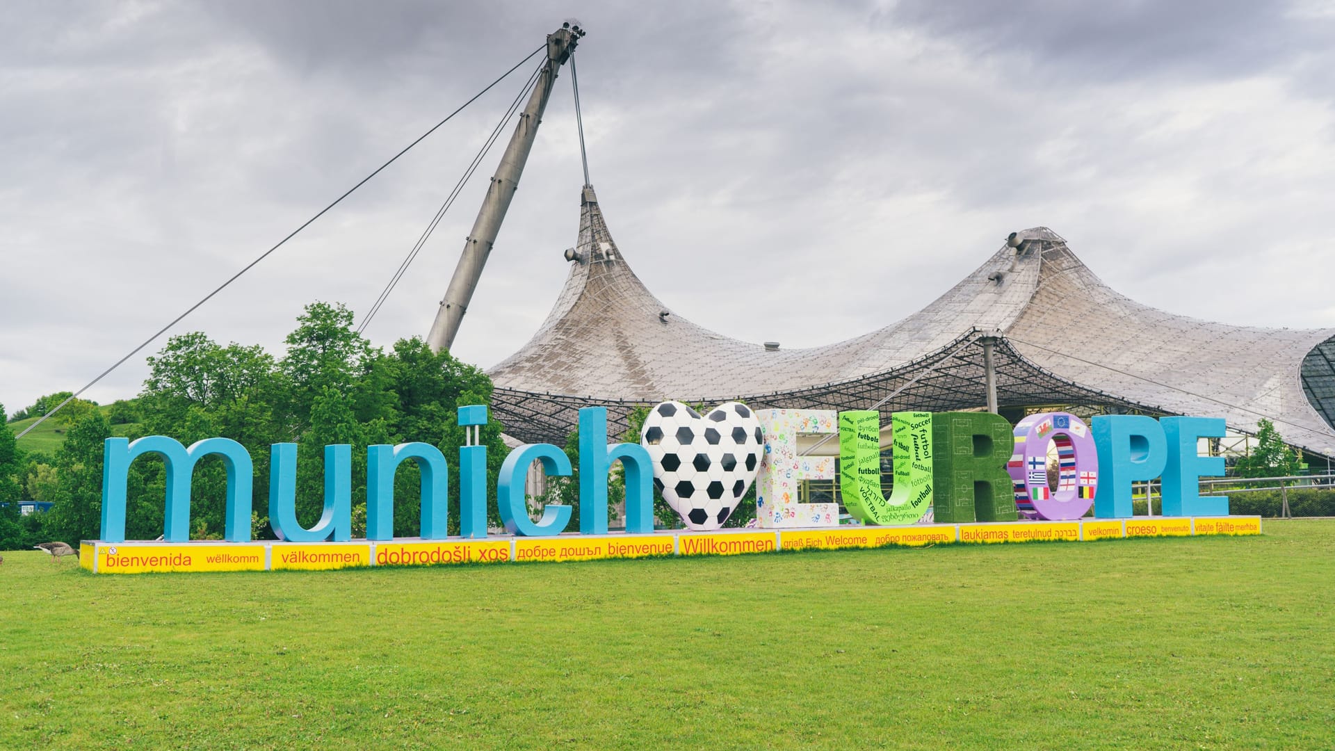 Ein Schriftzug weist auf die Fußball-EM in München hin: Im Olympiapark wird es 31 Tage lang eine Fan Zone geben.