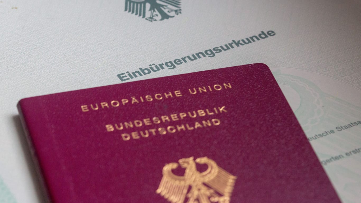 Einbürgerungsurkunde und deutscher Reisepass: Menschen können in Deutschland künftig schneller eingebürgert werden und dabei auch ihren ausländischen Pass behalten.