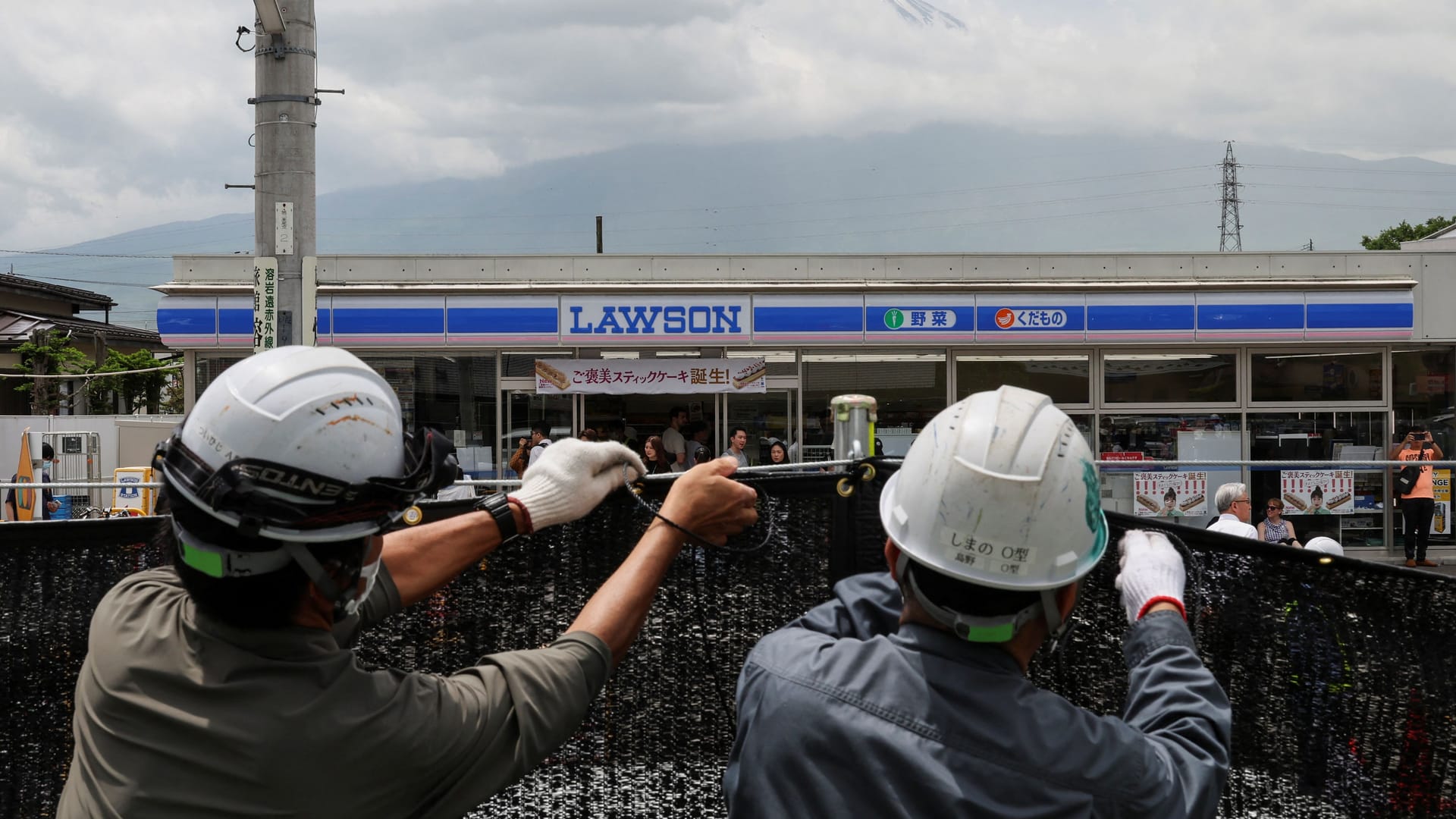 Kein Blick mehr auf den Fuji: Arbeiter spannen in Fujikawaguchiko einen schwarzen Sichtschutz auf.