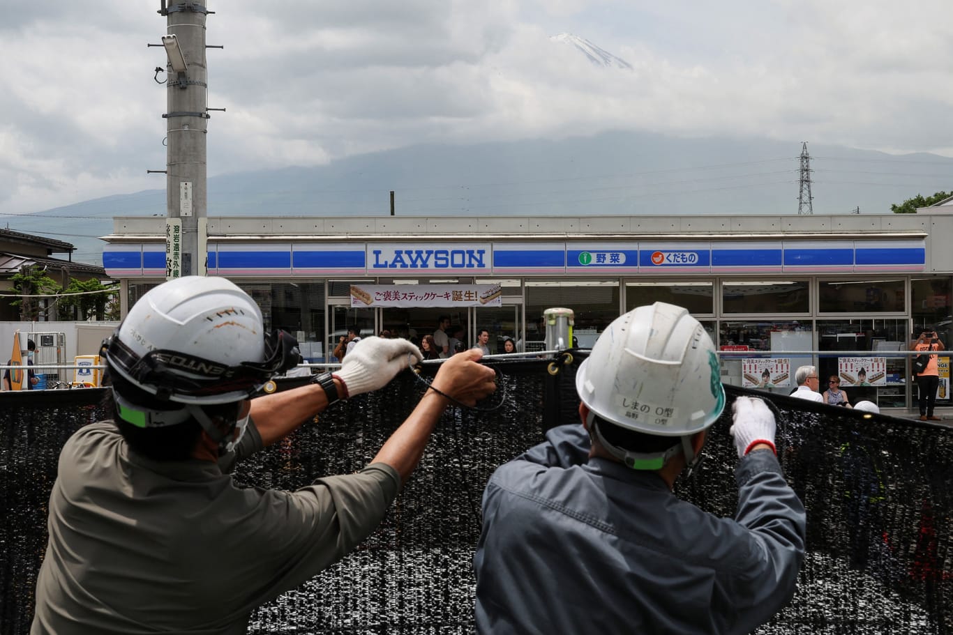 Kein Blick mehr auf den Fuji: Arbeiter spannen in Fujikawaguchiko einen schwarzen Sichtschutz auf.