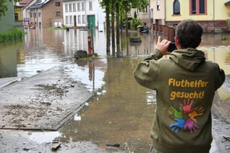 Ein Mann betrachtet die Schäden des Hochwassers.