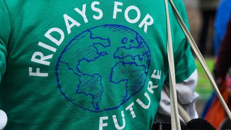 Eine Frau demonstriert in einem grünen T-Shirt mit der Aufschrift "Friday for Future": Die Klimabewegung hat in Köln eine große Demo angemeldet.