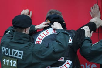 Polizeibeamte durchsuchen ein Münchner Hells Angels-Mitglied. Welche Gefahr geht von den Rockern wirklich aus?