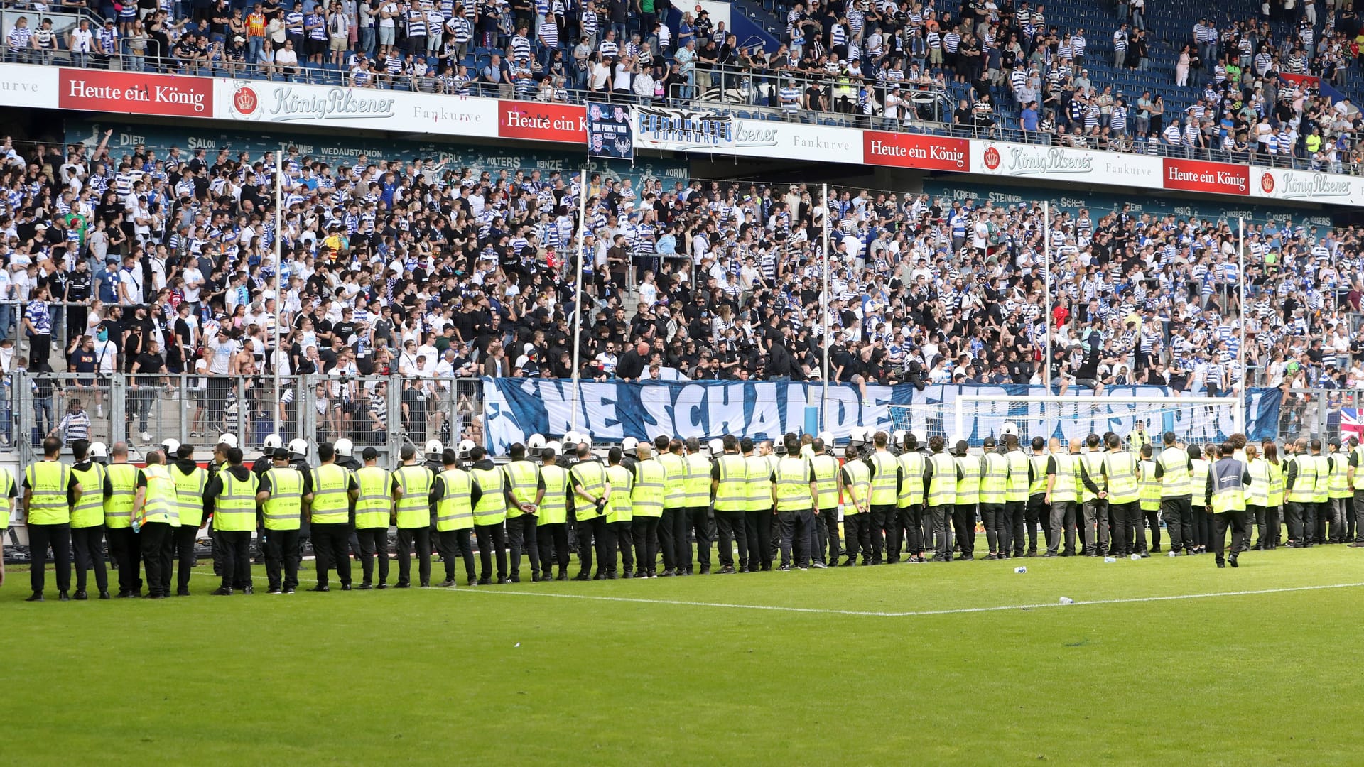 Die wütende Fankurve im Duisburger Stadion vor Dutzenden Ordnern.