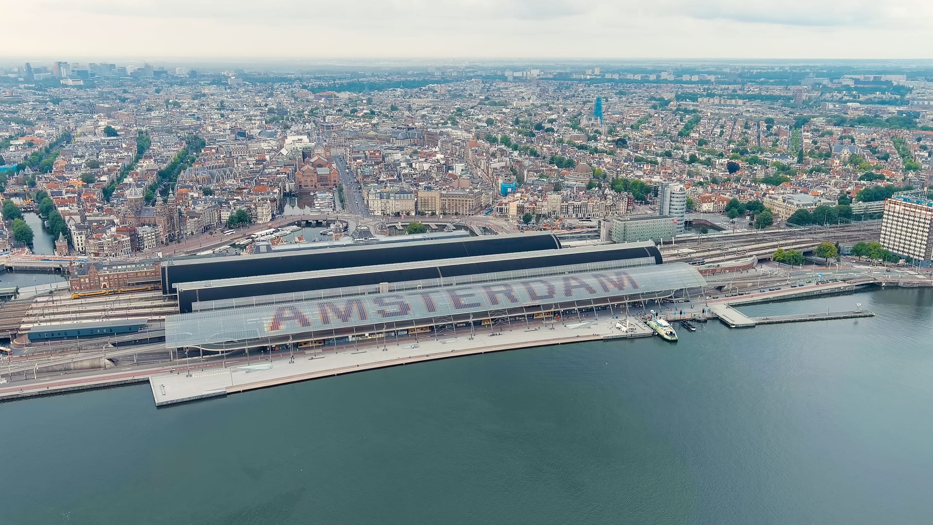 Amsterdam, Netherlands. Amsterdam Central Station. Amsterdam Centraal - The largest train station in the city, built in 1889. Bay IJ (Amsterdam), Aerial View