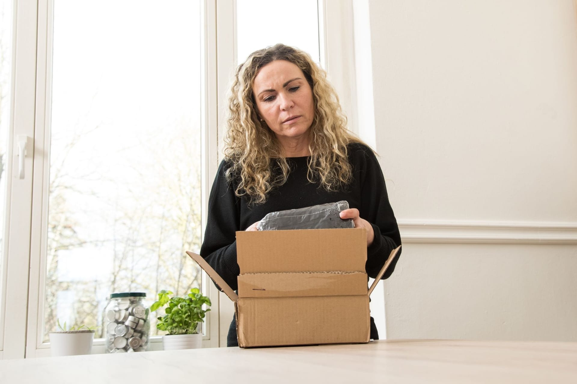 Eine Frau öffnet ein Paket