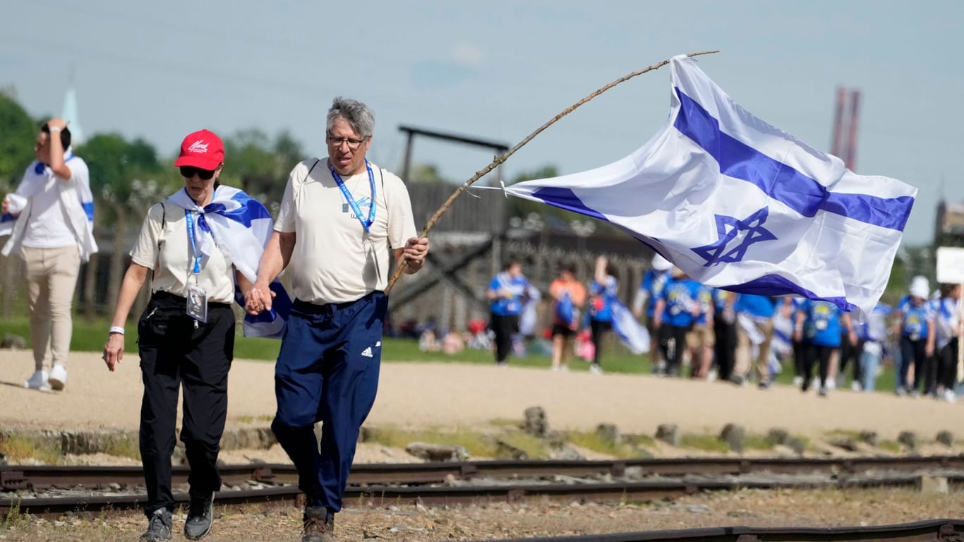 Menschen gehen durch das ehemalige deutsche Vernichtungslager Auschwitz-Birkenau: Bei dem "Marsch der Lebenden" gedenken tausende Juden den Opfern der Schoah.