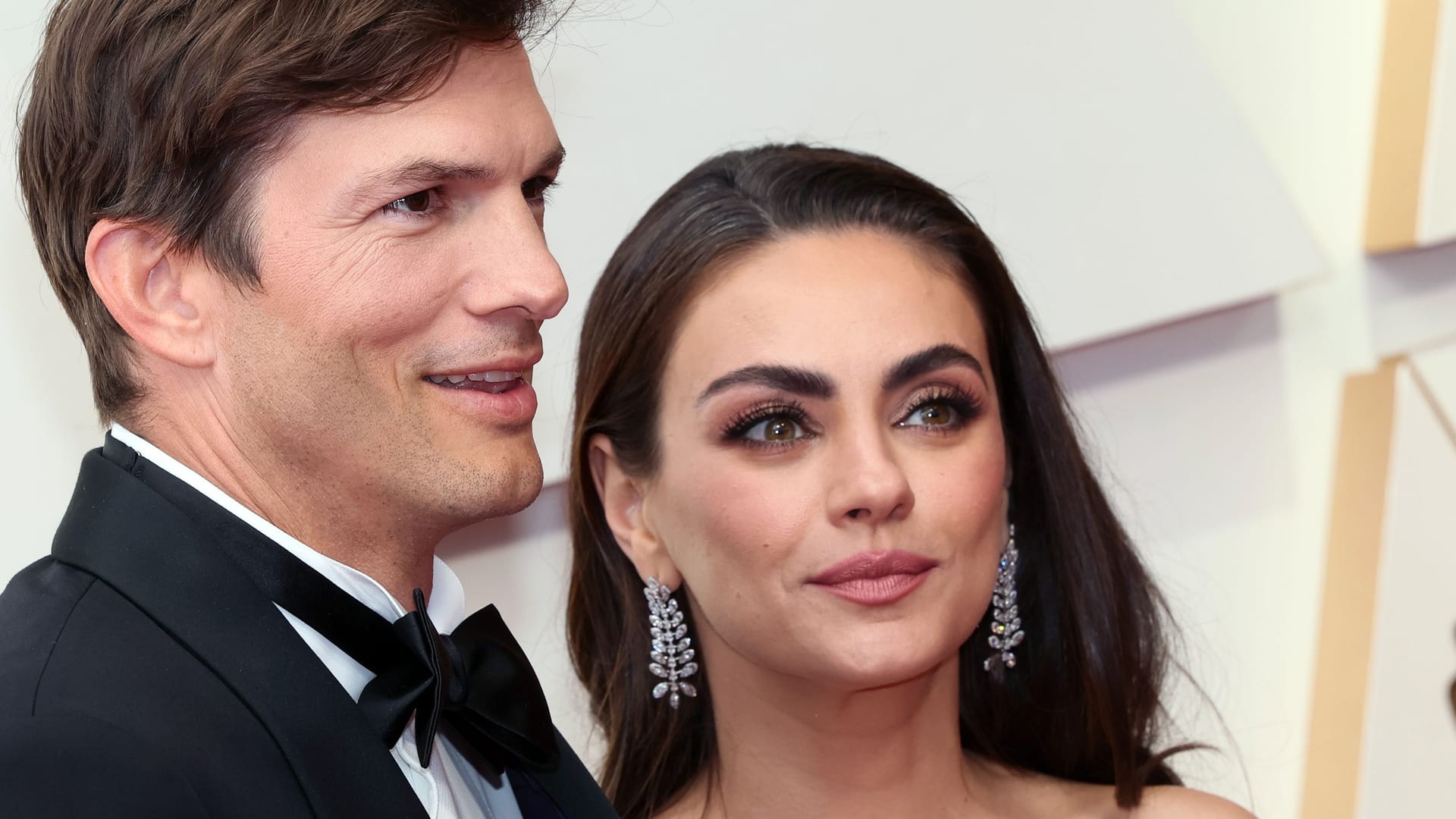 Ashton Kutcher und Mila Kunis posieren auf dem roten Teppich.