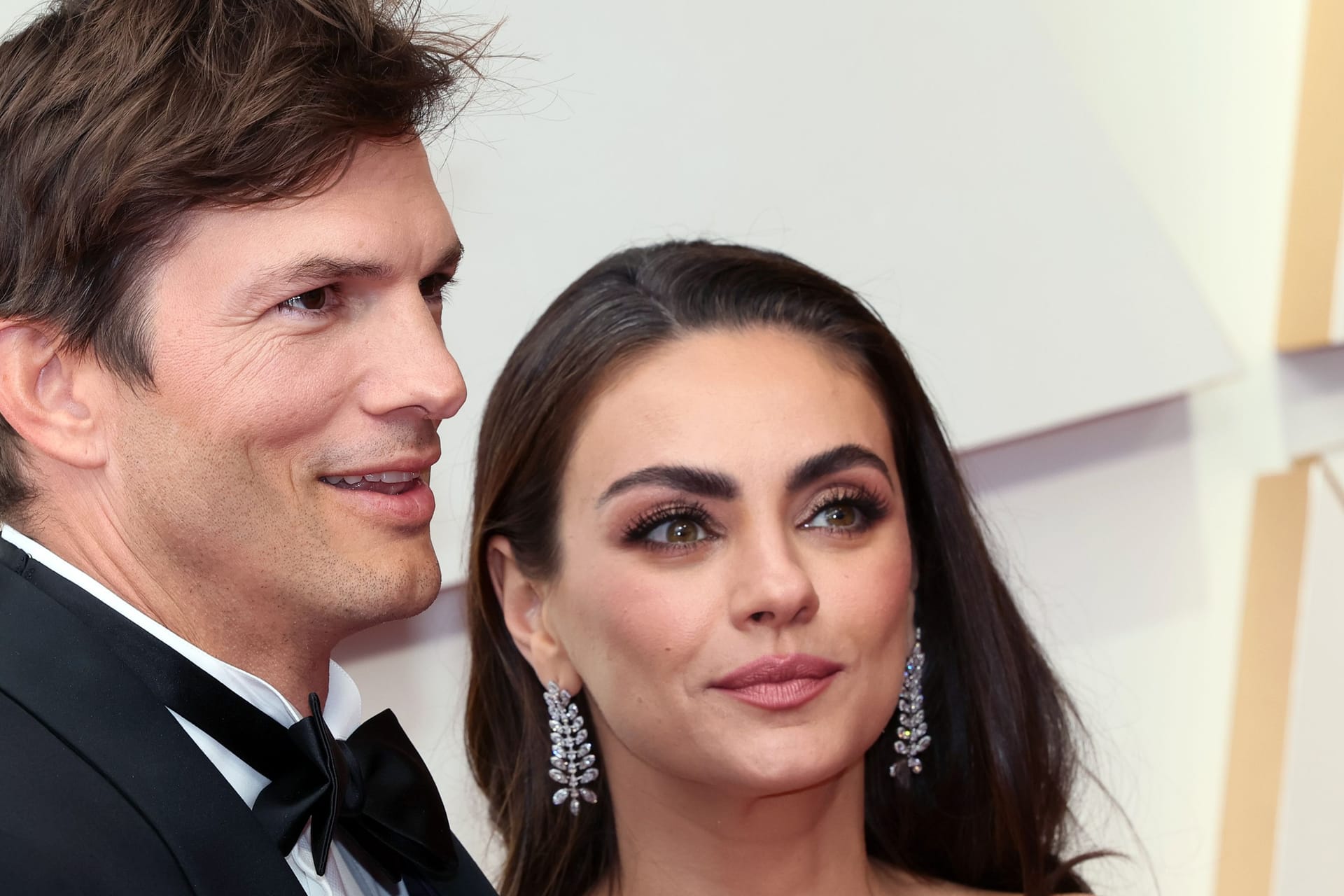 Ashton Kutcher und Mila Kunis posieren auf dem roten Teppich.