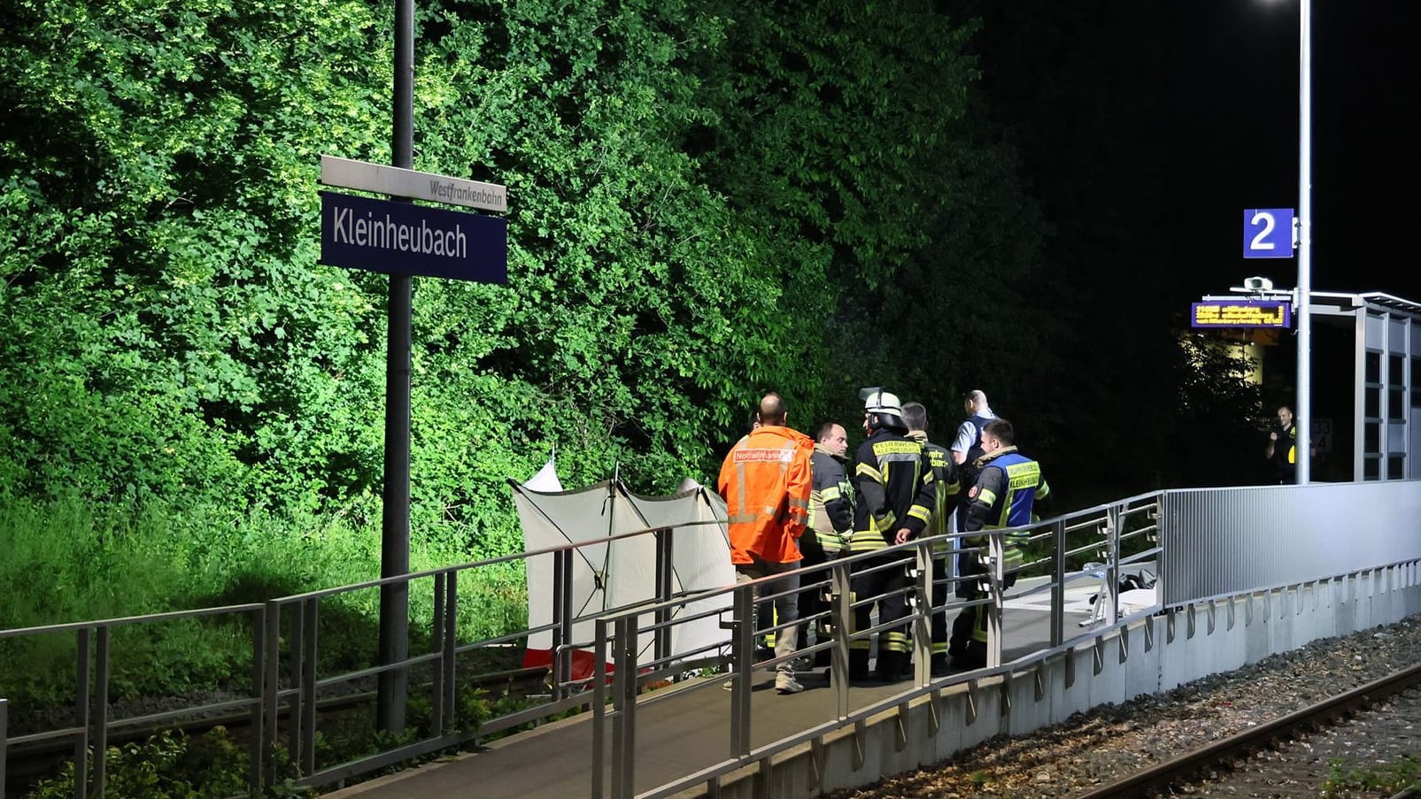 Bayern, Kleinheubach: Rettungskräfte stehen an einem Bahnsteig in Kleinheubach. Dort sind zwei Männer unter ungeklärten Umständen ums Leben gekommen.