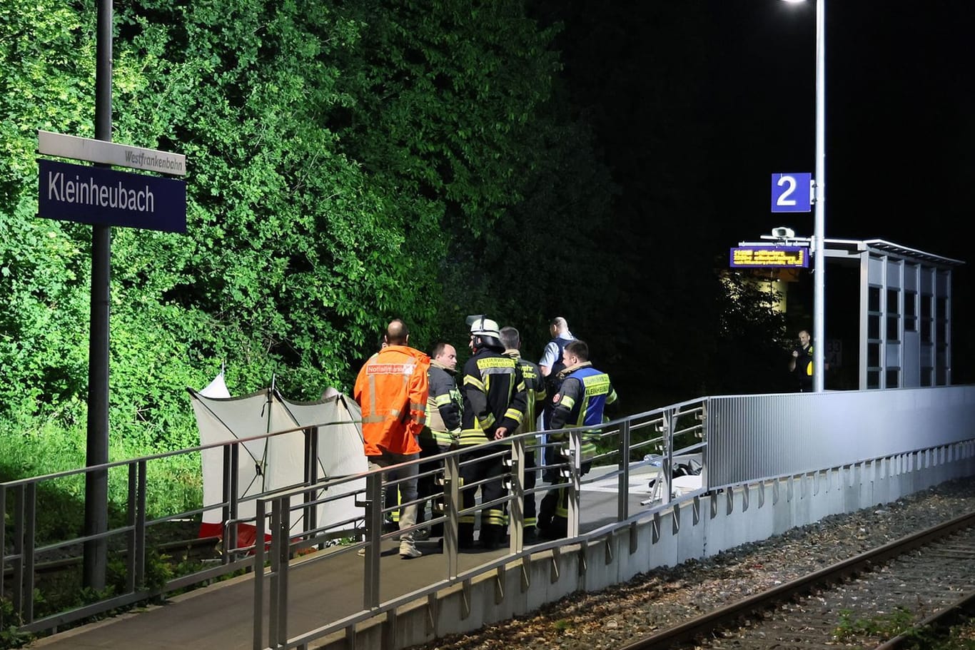 Bayern, Kleinheubach: Rettungskräfte stehen an einem Bahnsteig in Kleinheubach. Dort sind zwei Männer unter ungeklärten Umständen ums Leben gekommen.