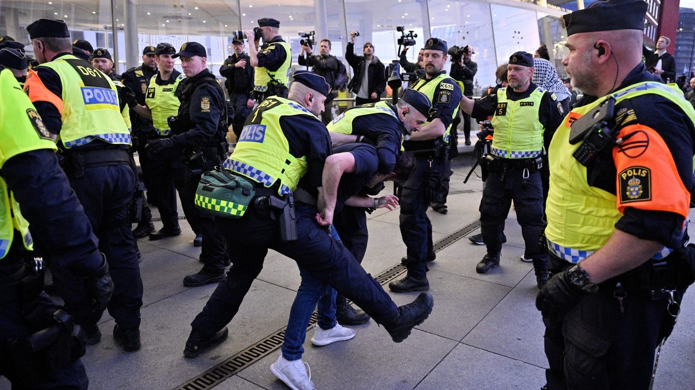 Polizisten in Malmö führen einen Demonstrierenden vor der Halle ab.