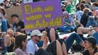Ein Schild mit der Aufschrift «Elon, wir wissen, wo dein Auto steht» halten Teilnehmer einer Protestveranstaltung vor dem Werk von Tesla in Grünheide in den Händen.