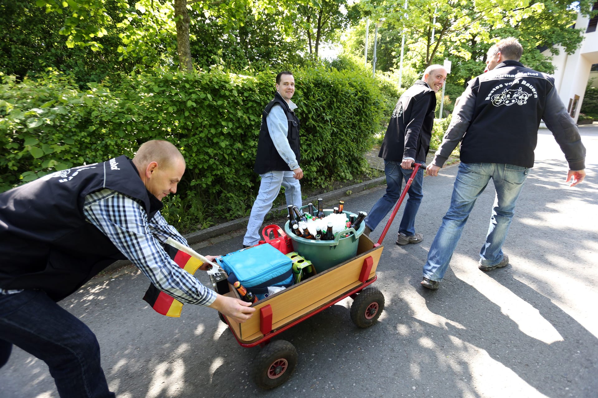 Männerpartie: Eine Gruppe junger Männer feiert den Vatertag mit einem mit Bier gefüllten Bollerwagen.