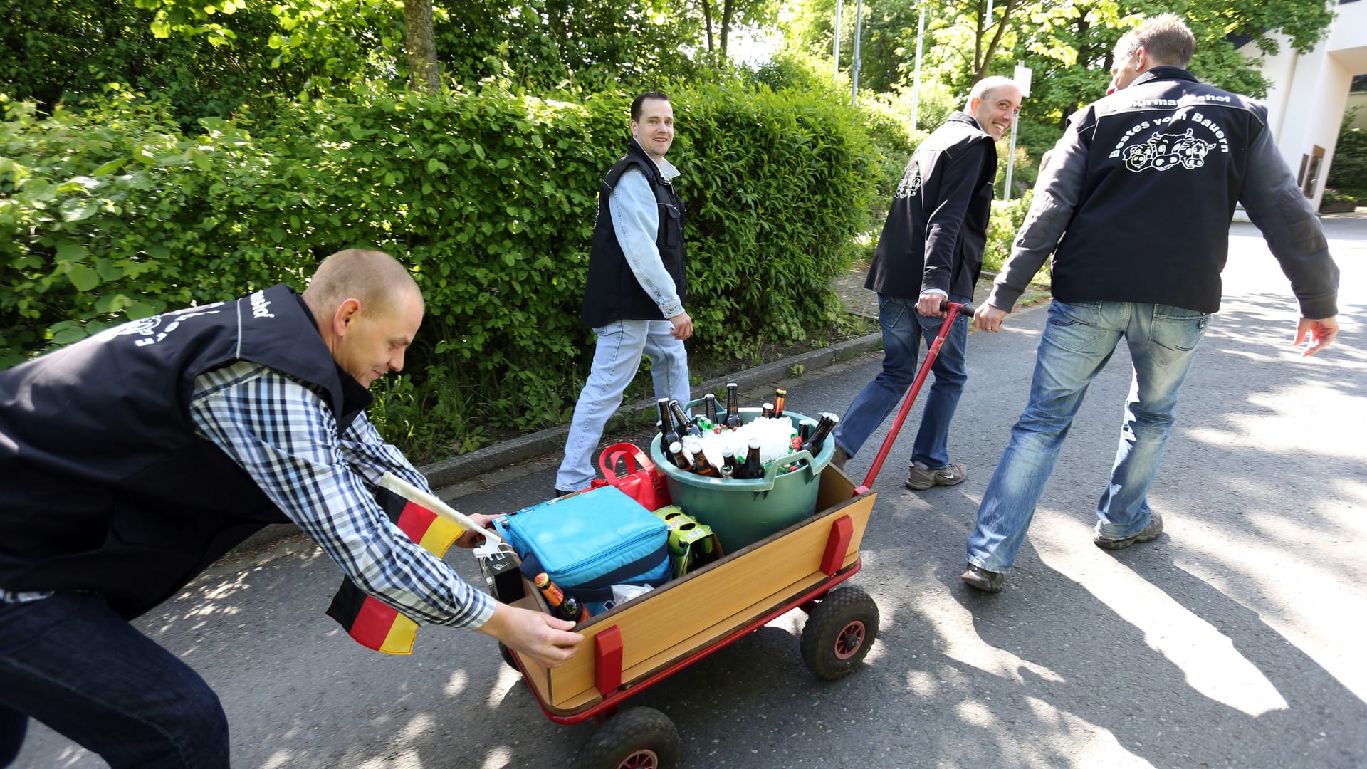 Männerpartie: Eine Gruppe junger Männer feiert den Vatertag mit einem mit Bier gefüllten Bollerwagen.