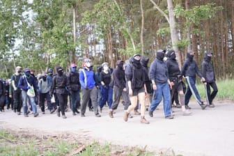 Aktivisten begeben sich durch den Wald zum Tesla-Zwischenlager in Neuhardenberg.