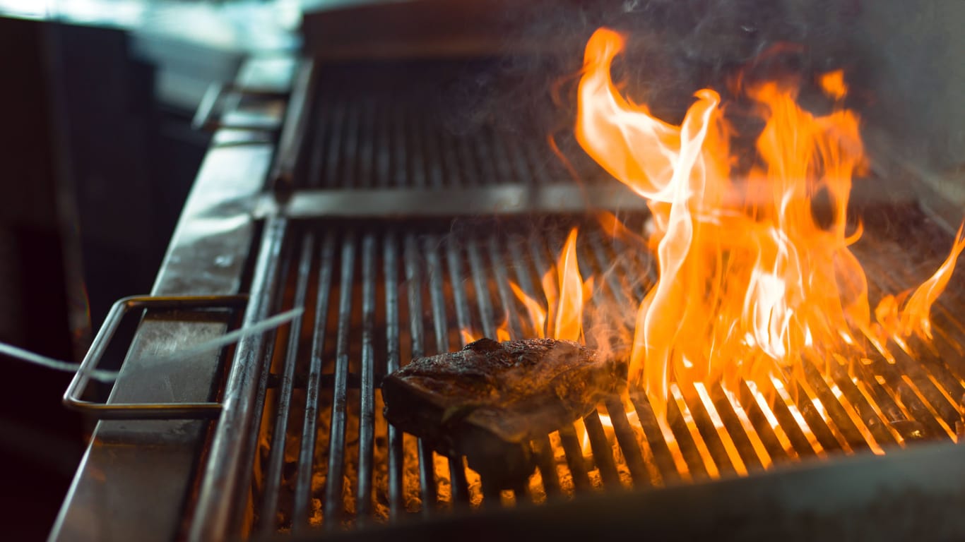 Steak wird in einer Restaurantküche gegrillt (Symbolfoto): In Essen sind Lebensmittelkontrolleure fündig geworden.