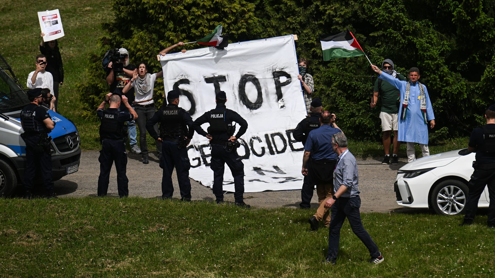 Pro-palästinensische Demonstranten rollen neben dem "Marsch der Lebenden" ein Banner aus, das Israel einen Völkermord an Palästinensern in Gaza vorwirft. Sie stören damit das Gedenken.