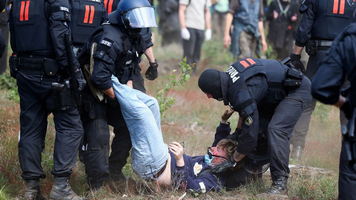 Polizisten tragen einen Aktivisten aus der Blockade weg.