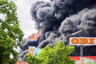 Flammen und dichter Qualm sind bei einem Brand in Berlin-Lichterfelde in der Rauchsäule zu sehen.