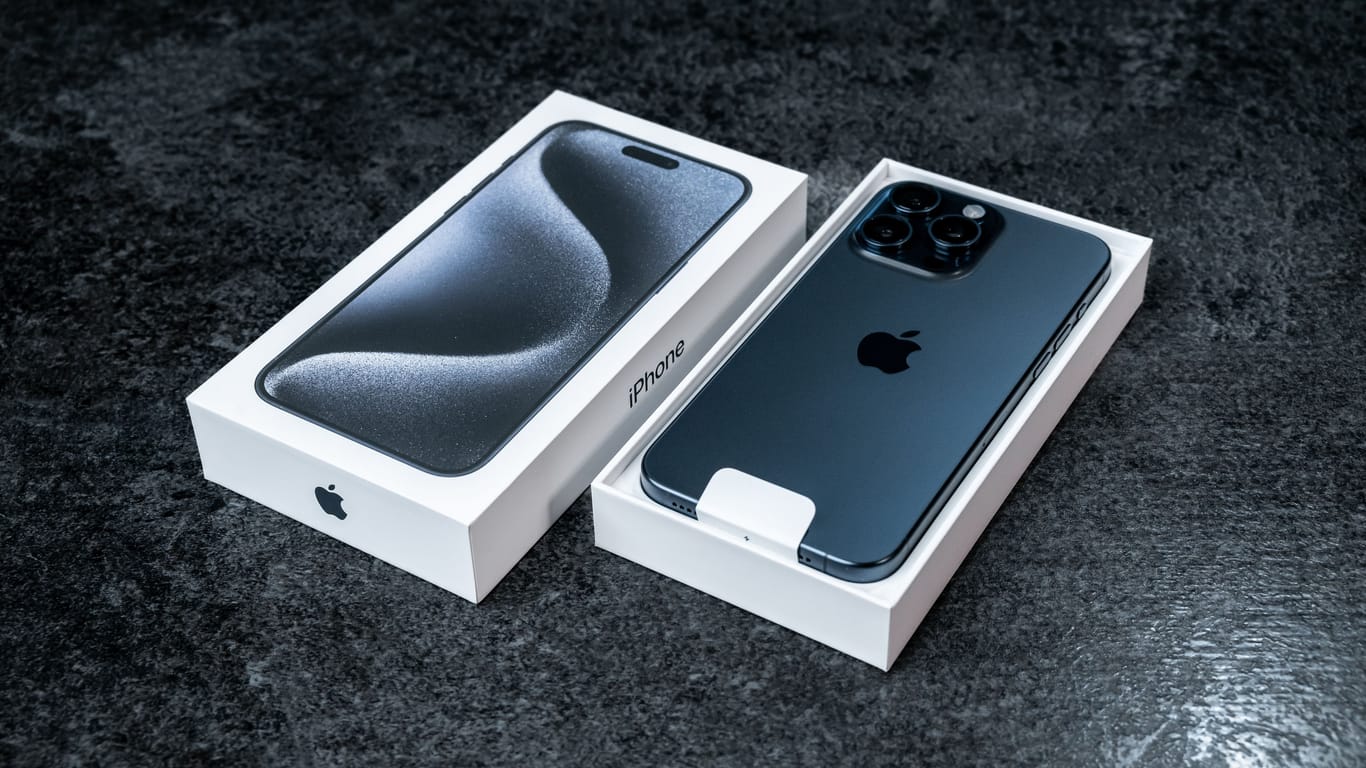 Jurmala, Latvia - 30 11 2023: Box and new smarphone apple iPhone 15 Pro Max in Blue Titanium color on grey table.