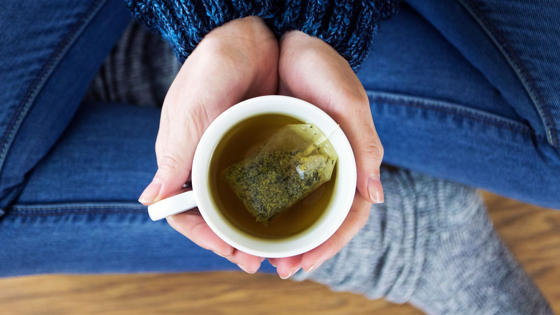 Eine Frau hält eine Tasse Tee in den Händen.