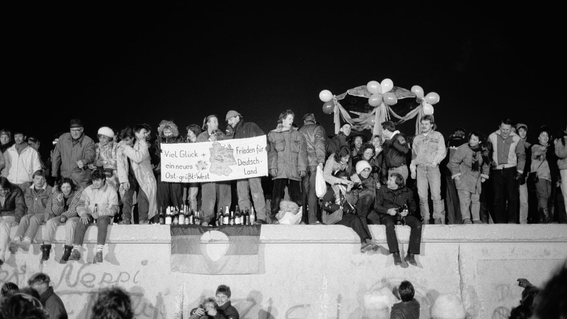 Menschen auf der Berliner Mauer an Silvester 1989.