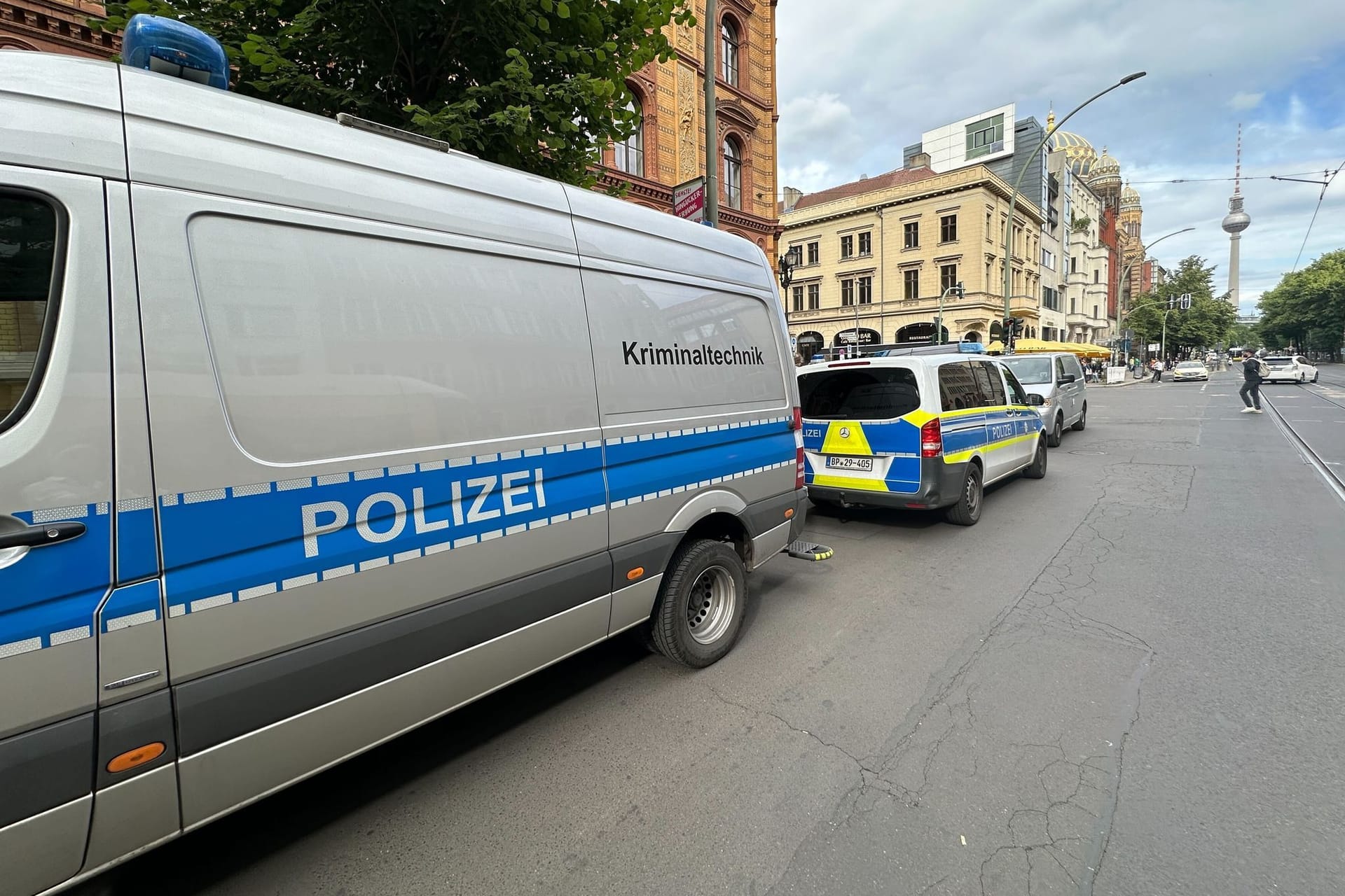 29.05.2024, Berlin: Fahrzeuge der Polizei stehen in der Oranienburger Straße am Straßenrand. Ein Mensch ist unter einen Zug am S-Bahnhof Oranienburger Straße in Berlin geraten und gestorben