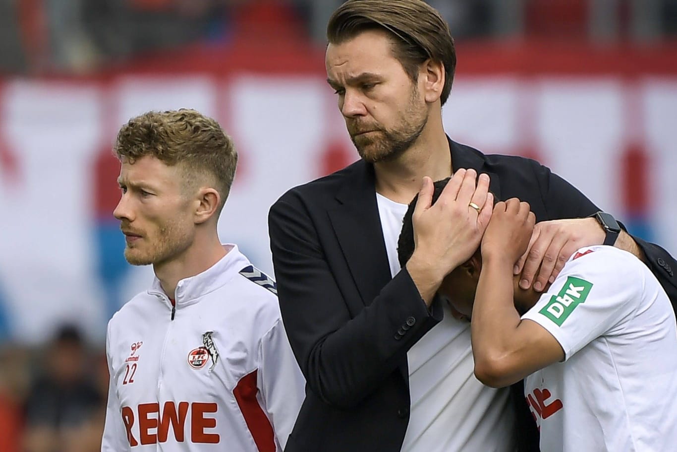 Lizenzspieler-Chef Kessler tröstet Linton Maina: Der 1. FC Köln geht in die 2. Bundesliga.