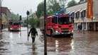 Feuerwehrleute bewegen sich und ihre LKW durch das Hochwasser in der Fischbachstrasse in Saarbrücken.