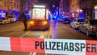 Ein Polizist steht mit einer Maschinenpistole neben einer Straßenbahn (Archivbild): Bei Schüssen in der Nürnberger Südstadt war 2022 ein Mann gestorben und ein weiterer schwer verletzt worden.