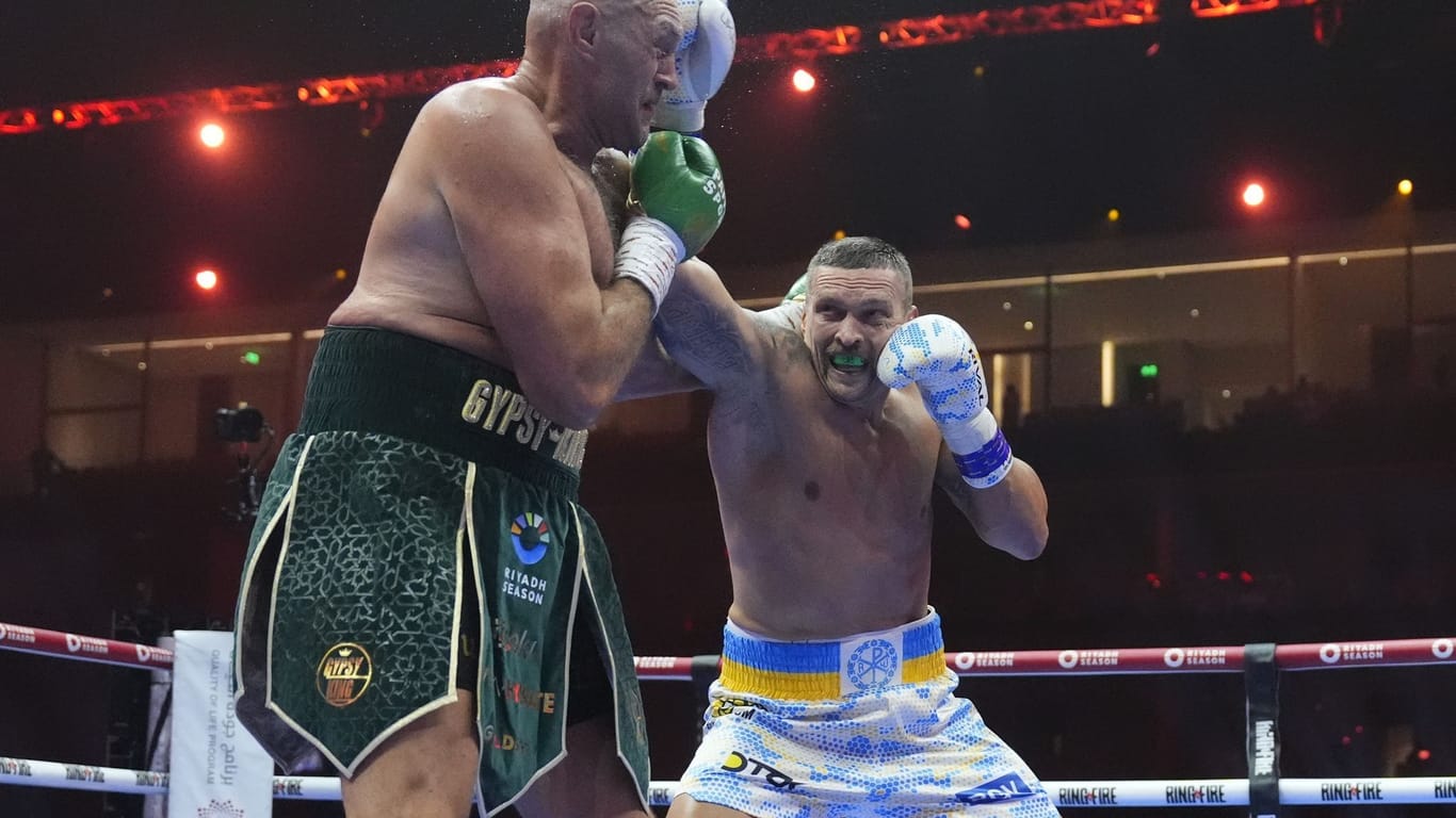 Tyson Fury (l.) muss einen Schlag von Alexander Usyk einstecken. Der Ukraine holte sich den Titel im Schwergewicht.
