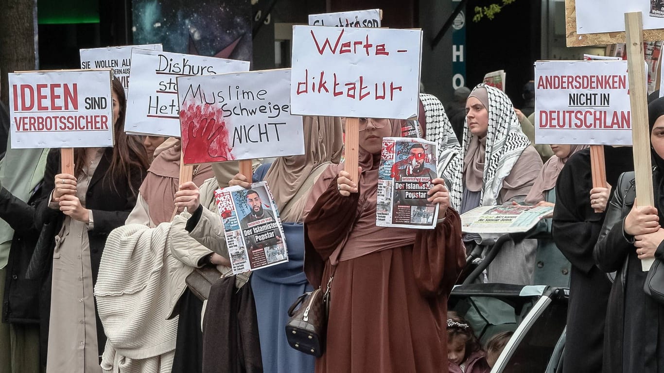 Teilnehmende der Kalifats-Demo vom 27. April halten Schilder hoch: Am Samstag ist eine erneute Kundgebung geplant.