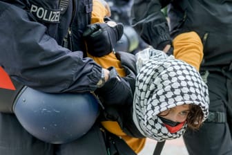 A woman is carried away by police officers during a pro-Palestinians demonstration by the group "Student Coalition Berlin" in the theater courtyard of the 'Freie Universität Berlin' university in Berlin, Germany, Tuesday, May 7, 2024.
